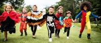 A bunch of children in costume running.